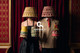 ClothShop marketing campaign for Christopher Farr Cloth, featuring a couple wearing lampshades on their heads and holding 6" wall light shades in front of an exit sign at the Rivoli Ballroom. Photographed by Sofia Spring.